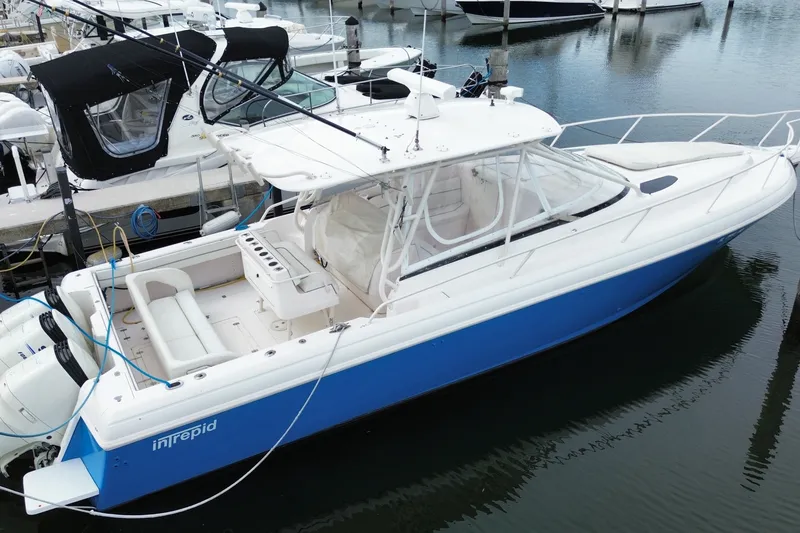 Slide: The Image of 2001 Intrepid 377 Walkaround boat docked in marina, featuring sleek design and spacious deck. - 49