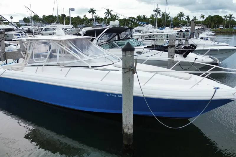 Slide: The Image of 2001 Intrepid 377 Walkaround boat docked in a marina with other vessels. - 2