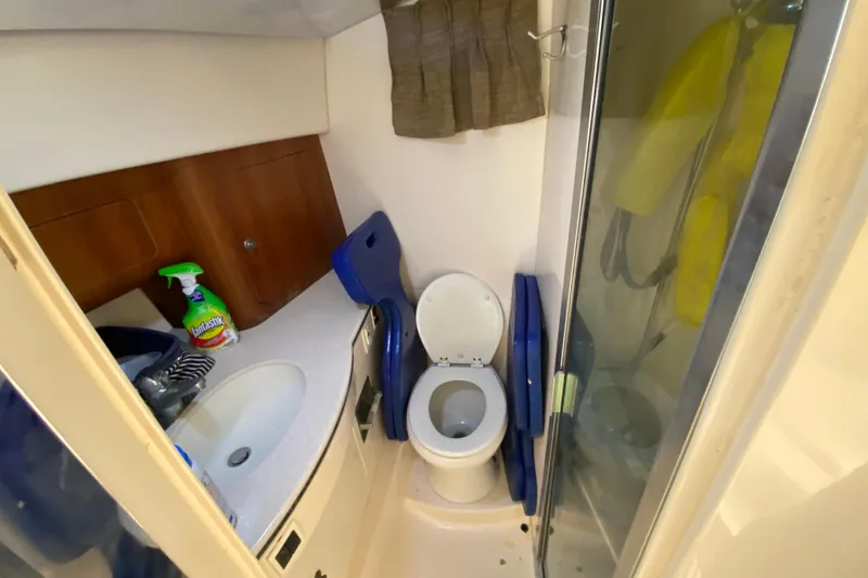 Slide: The Image of 2001 Intrepid 377 Walkaround boat bathroom with toilet, sink, and cleaning supplies. - 39