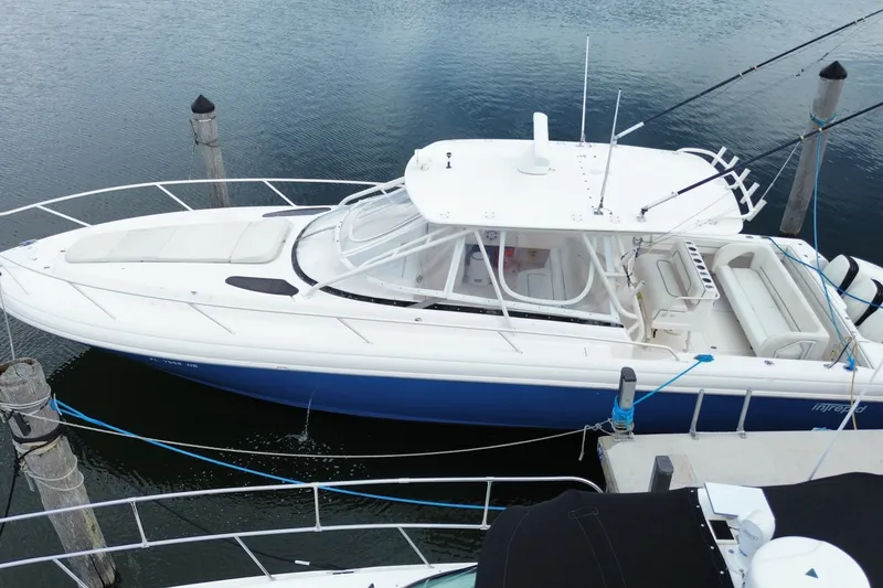 Slide: The Image of 2001 Intrepid 377 Walkaround boat docked, featuring sleek design and spacious deck. - 14