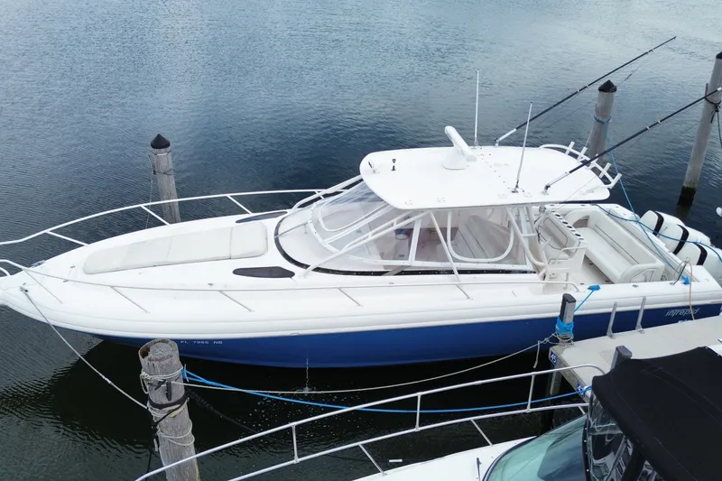 Slide: The Image of 2001 Intrepid 377 Walkaround boat docked, featuring sleek design and spacious deck. - 3