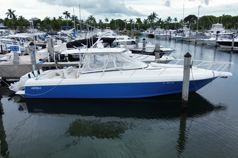 The Image of 2001 Intrepid 377 Walkaround boat docked in a marina with other vessels. - 0