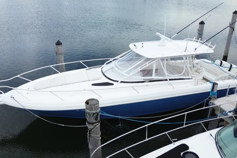 Slide: The Image of 2001 Intrepid 377 Walkaround boat docked in calm waters, side view. - 5