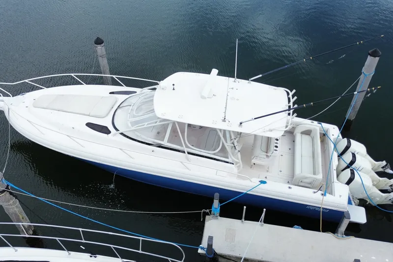 Slide: The Image of 2001 Intrepid 377 Walkaround boat docked, aerial view, white and blue design. - 12