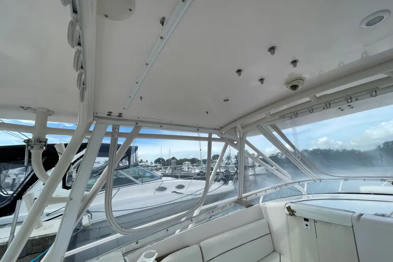 Slide: The Image of 2001 Intrepid 377 Walkaround boat interior with white seating and marina view. - 34