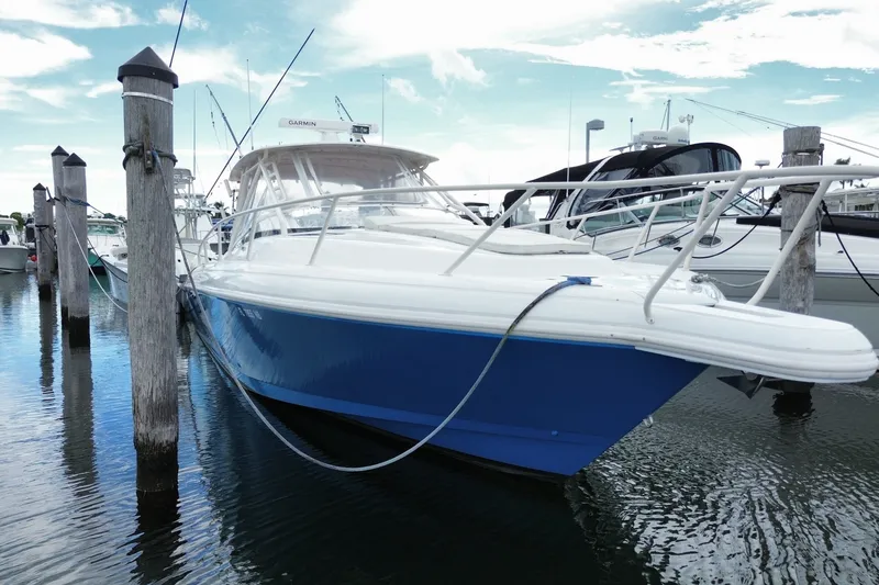 Slide: The Image of 2001 Intrepid 377 Walkaround boat docked in marina, blue hull, clear sky. - 11