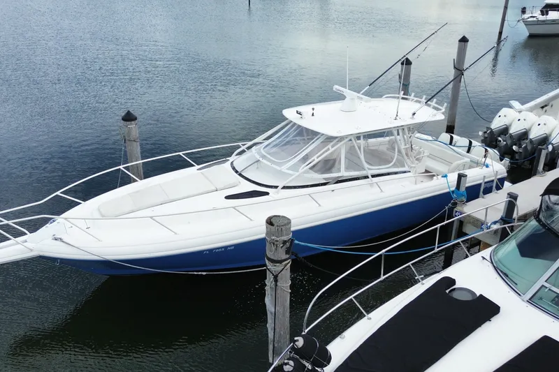 Slide: The Image of 2001 Intrepid 377 Walkaround boat docked on calm water, featuring sleek design and multiple engines. - 7
