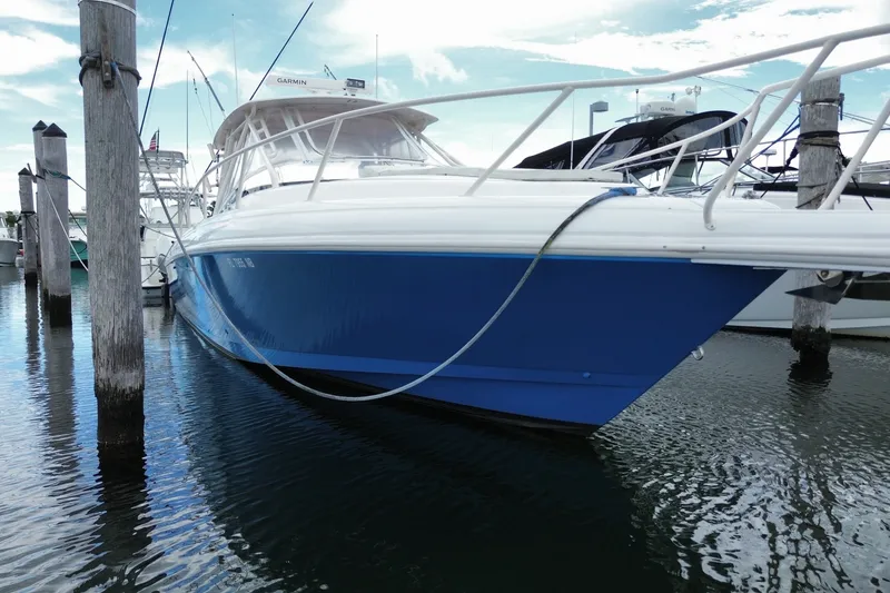 Slide: The Image of 2001 Intrepid 377 Walkaround boat docked in marina, blue hull, calm water. - 9