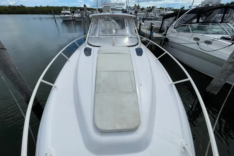 Slide: The Image of 2001 Intrepid 377 Walkaround boat docked at marina, featuring spacious deck and sleek design. - 15