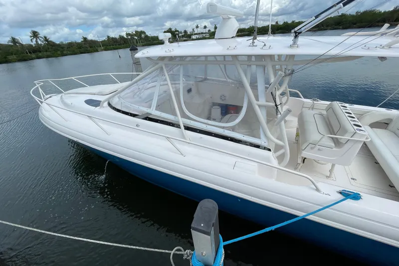 Slide: The Image of 2001 Intrepid 377 Walkaround boat docked on calm water under cloudy skies. - 24