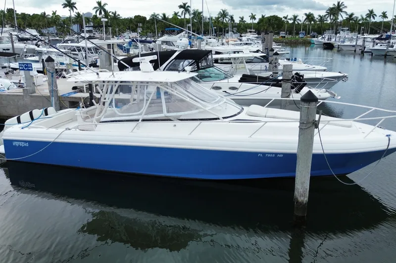 Slide: The Image of 2001 Intrepid 377 Walkaround boat docked in a marina with other vessels. - 4