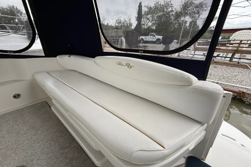 Slide: The Image of White leather seating on a 2000 Sea Ray 340 Sundancer boat, docked with outdoor view. - 9