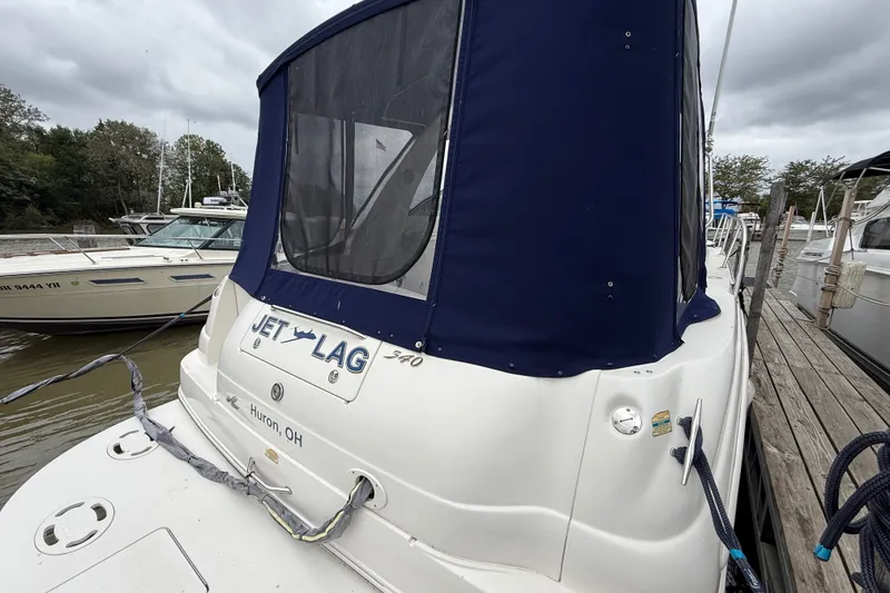 Slide: The Image of 2000 Sea Ray 340 Sundancer docked, featuring blue canopy and "Jet Lag" name. - 3