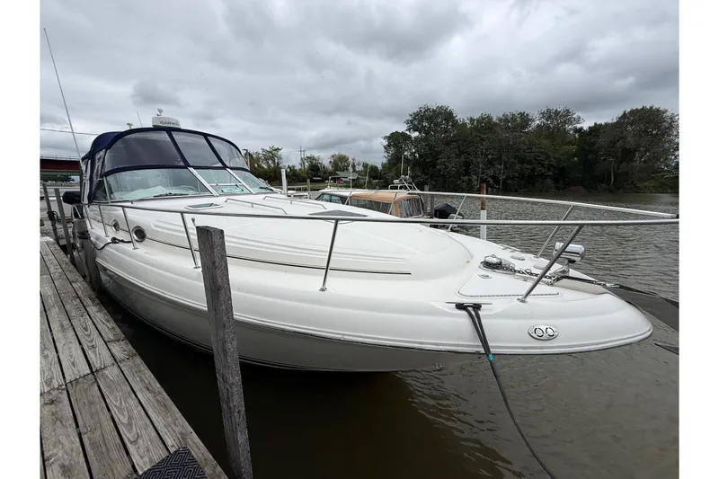 Slide: The Image of 2000 Sea Ray 340 Sundancer docked by a wooden pier on a cloudy day. - 6