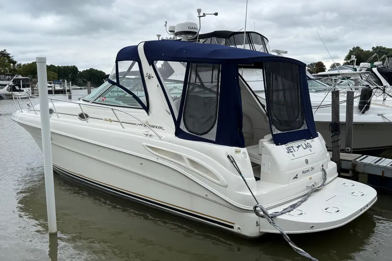 Slide: The Image of 2000 Sea Ray 340 Sundancer docked, featuring a blue canopy and sleek white design. - 0