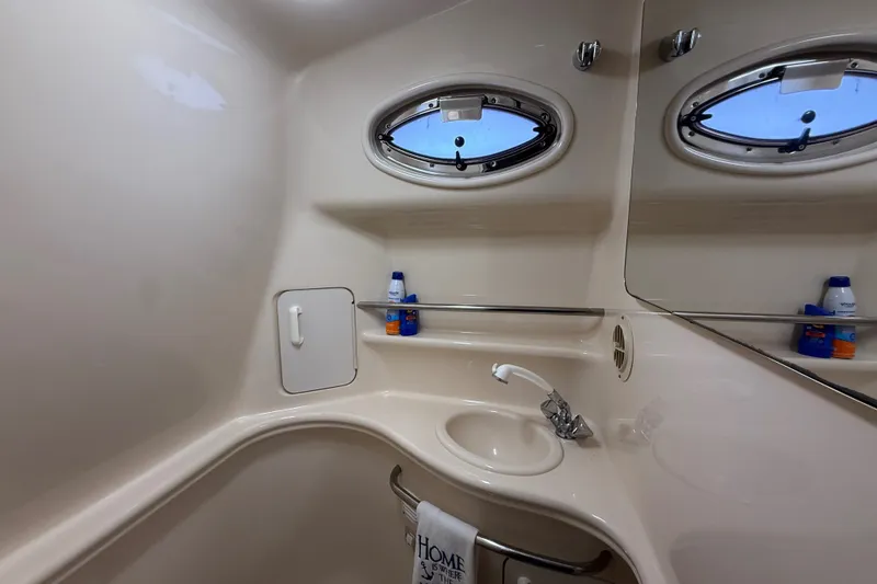 Slide: The Image of Interior of 2000 Sea Ray 340 Sundancer bathroom with sink and porthole windows. - 54