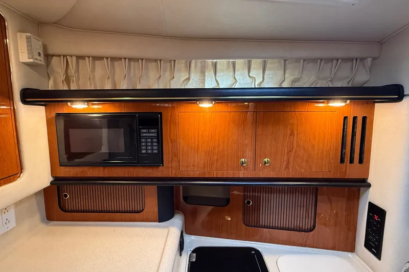 Slide: The Image of 2000 Sea Ray 340 Sundancer galley with microwave and wooden cabinetry. - 40
