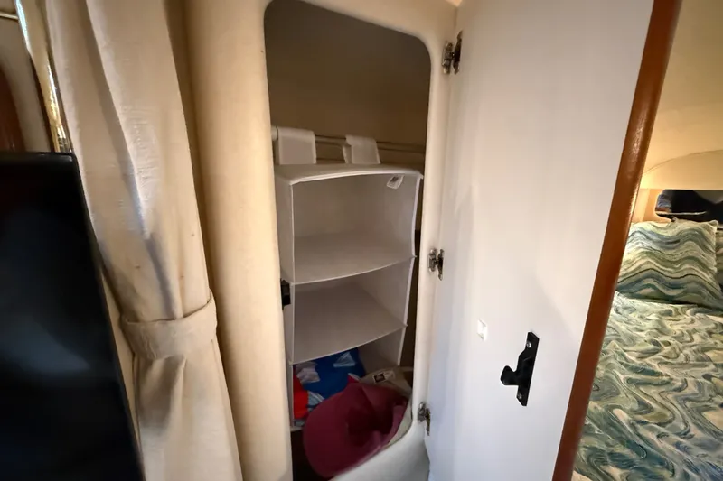 Slide: The Image of Interior storage of 2000 Sea Ray 340 Sundancer yacht with open closet and bed view. - 48