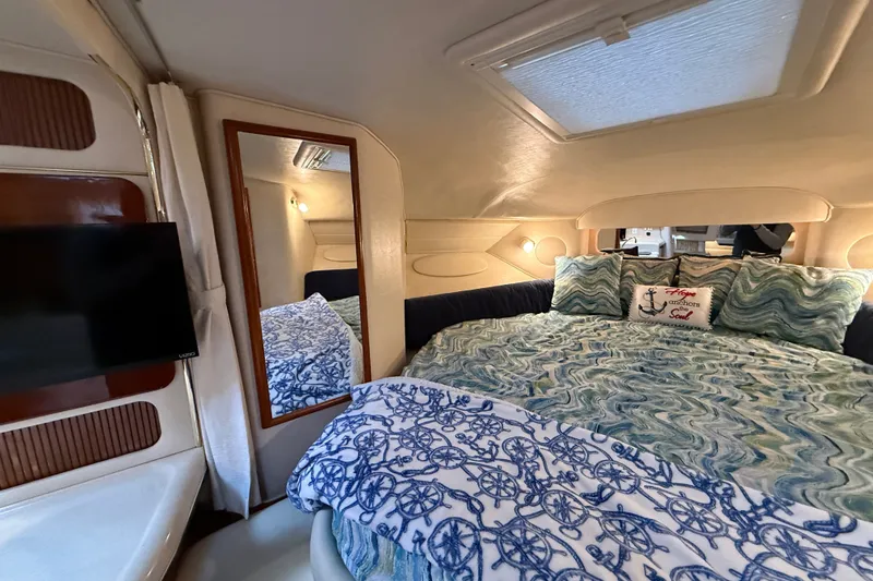 Slide: The Image of Cozy cabin interior of 2000 Sea Ray 340 Sundancer with nautical-themed bedding. - 45