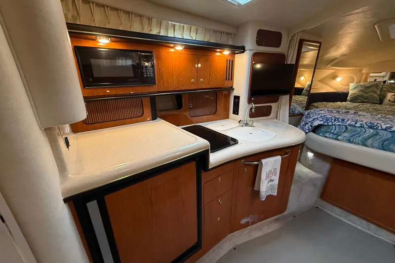 Slide: The Image of Interior of 2000 Sea Ray 340 Sundancer yacht with kitchenette and cozy sleeping area. - 35