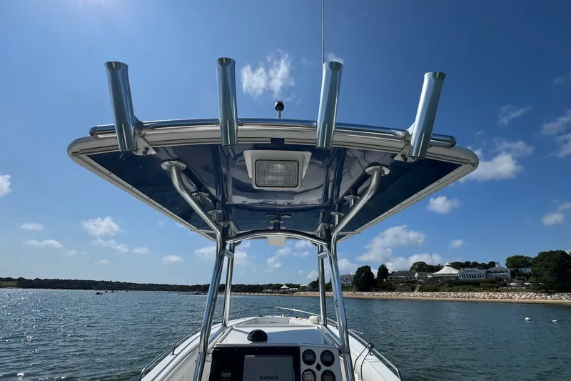 Slide: The Image of 2006 Regulator 26 Forward Seating boat on water, featuring T-top and console. - 3
