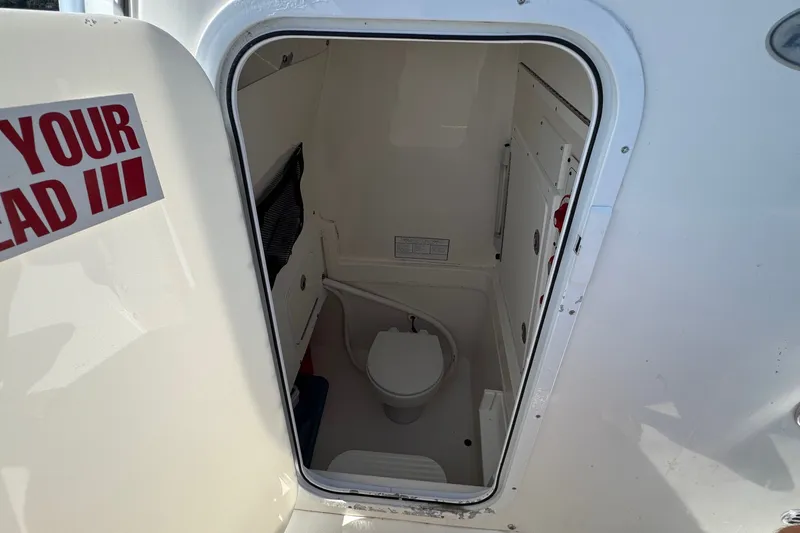 Slide: The Image of 2006 Regulator 26 Forward Seating boat interior with compact marine toilet. - 9