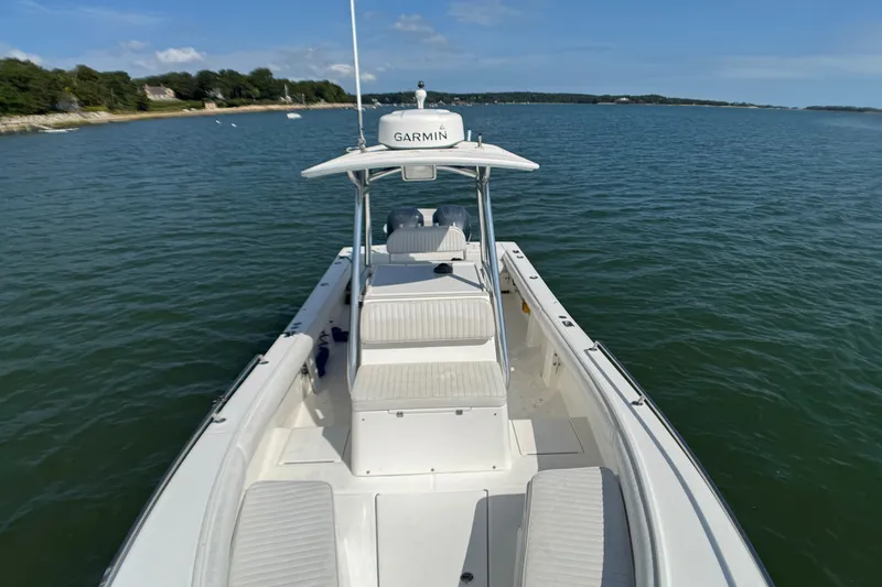 Slide: The Image of 2006 Regulator 26 Forward Seating boat on calm water, featuring Garmin equipment. - 7