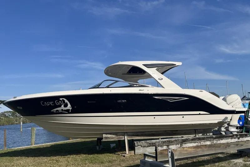 Slide: The Image of 2017 Sea Ray SLX 310 boat on display by the water under a clear blue sky. - 0