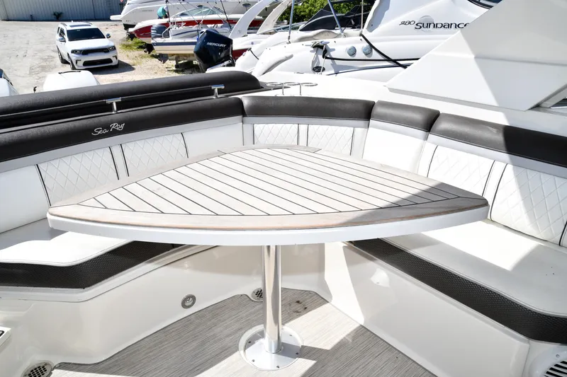 Slide: The Image of 2017 Sea Ray SLX 310 boat interior with elegant seating and wooden table. - 32