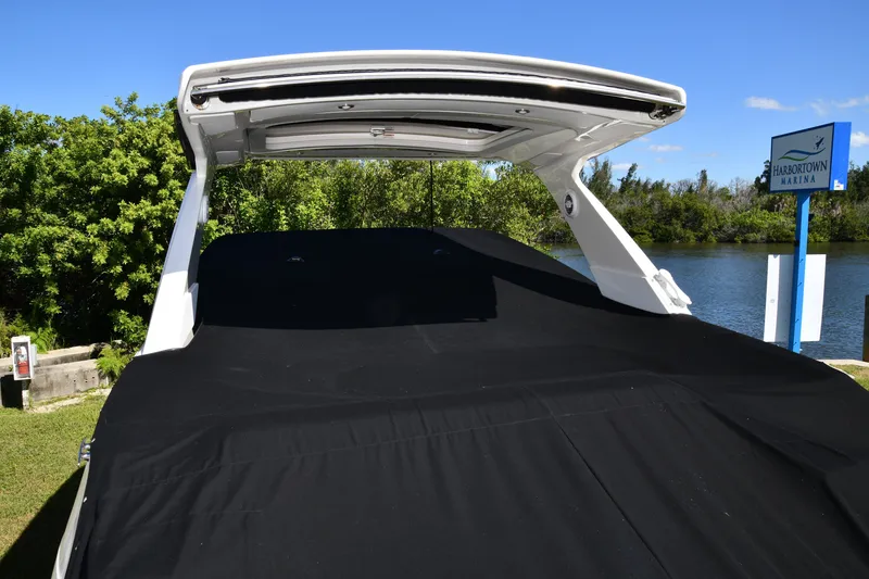 Slide: The Image of 2017 Sea Ray SLX 310 boat covered at Harbortown Marina, surrounded by lush greenery. - 18