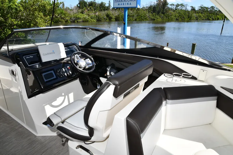 Slide: The Image of 2017 Sea Ray SLX 310 boat interior with Garmin navigation, sleek design, and waterfront view. - 30