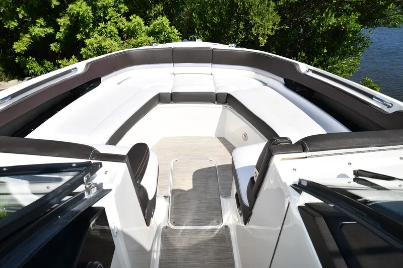 Slide: The Image of 2017 Sea Ray SLX 310 boat interior with white seating and wood flooring. - 21