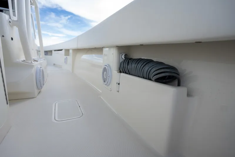 Slide: The Image of 2017 SeaVee 390Z boat deck with coiled hose and speakers under a blue sky. - 47