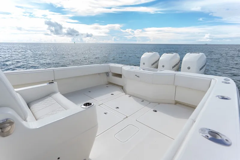 Slide: The Image of 2017 SeaVee 390Z boat deck with triple Mercury engines, ocean view, and clear sky. - 33