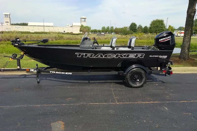 The Image of 2027 Tracker Super Guide V-16 SC boat on trailer, parked outdoors. - 0