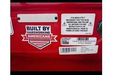 Slide: The Image of Stickers on a red boat reading "Built by Hardworking Americans" and safety instructions. - 12