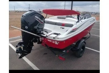 The Image of A red 2027 Tahoe T16 boat is on a trailer in a parking lot. - 0