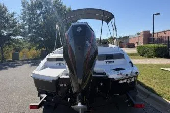 Slide: The Image of 2027 Tahoe T21 boat with outboard motor, parked outdoors on a sunny day. - 6
