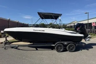 The Image of 2027 Tahoe T21 boat on trailer, black and white design, parked outdoors. - 0