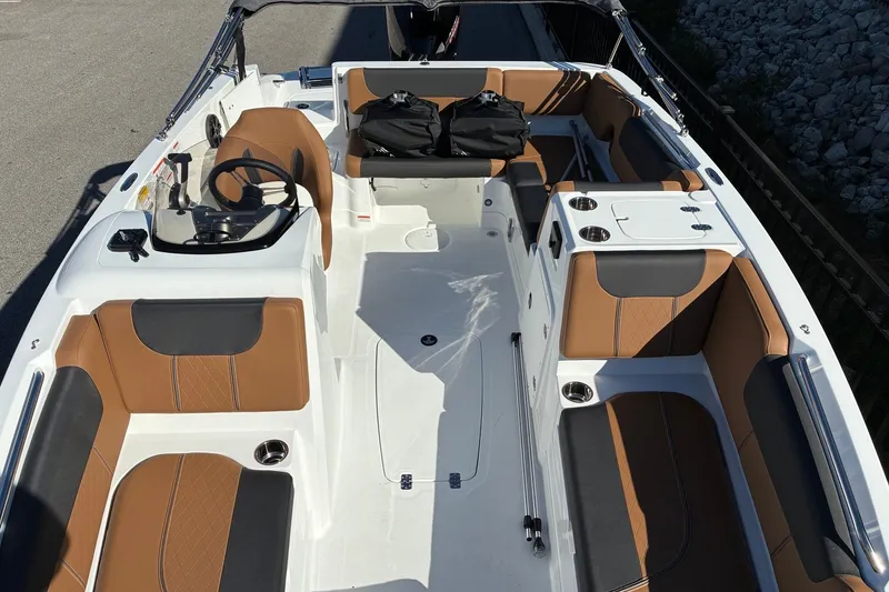 Slide: The Image of 2027 Tahoe 1950 boat interior with brown and black seating, steering wheel, and storage compartments. - 6