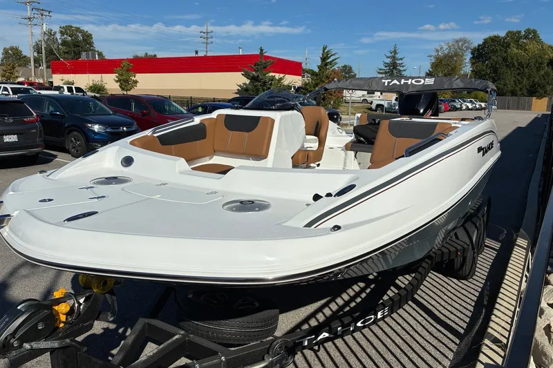 Slide: The Image of 2027 Tahoe 1950 boat on trailer in parking lot, featuring sleek design and brown seating. - 5