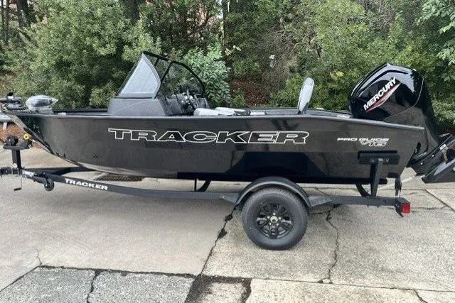 The Image of 2027 Tracker Pro Guide V-16 WT boat on trailer, parked outdoors. - 0