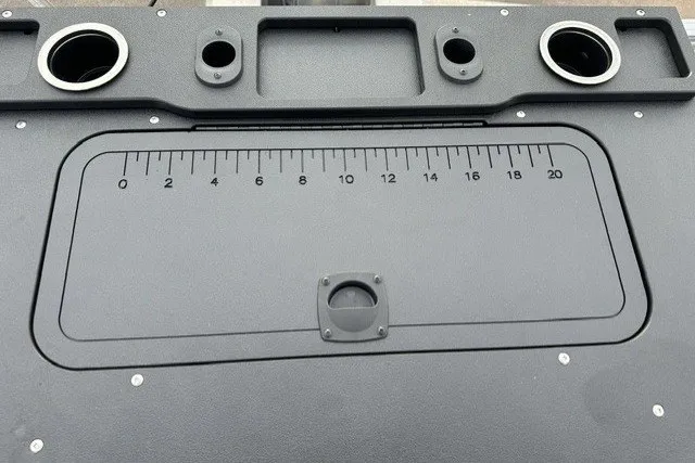 Slide: The Image of Control panel of 2027 Sun Tracker SportFish 22 DLX with integrated ruler and cup holders. - 26