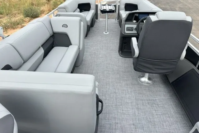 Slide: The Image of 2027 Sun Tracker SportFish 22 DLX pontoon boat interior with gray seating and modern helm. - 22