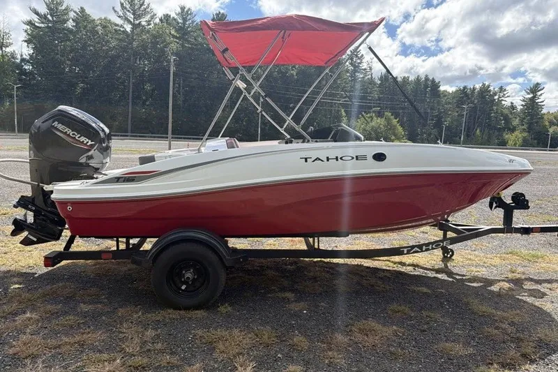 Slide: The Image of 2027 Tahoe T16 boat with red and white design, on trailer, under a cloudy sky. - 2