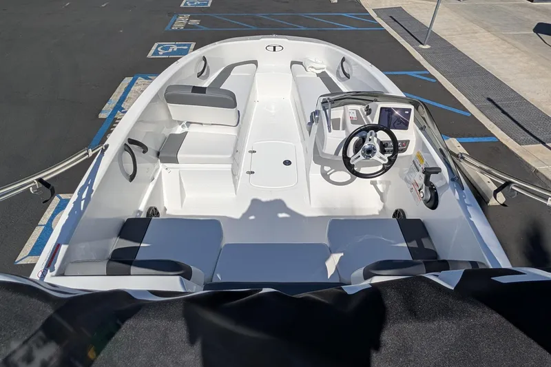 Slide: The Image of 2027 Tahoe T16 boat interior with seating and steering wheel in a parking lot. - 10