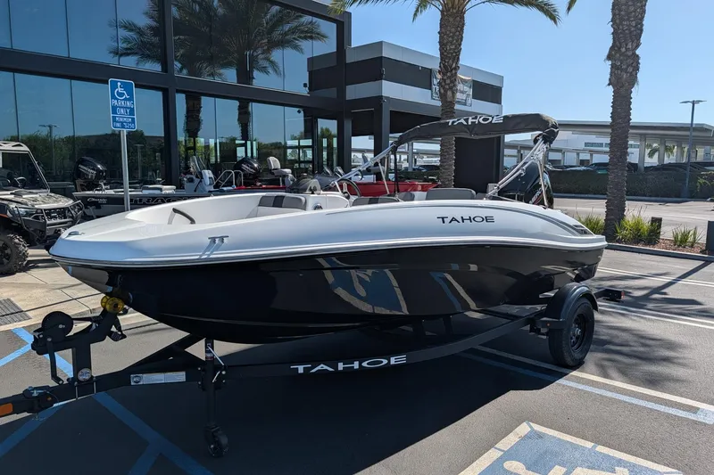 Slide: The Image of 2027 Tahoe T16 boat displayed outdoors, parked on a trailer near palm trees. - 3