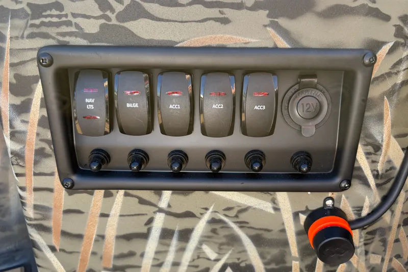Slide: The Image of Control panel of 2027 Tracker Grizzly 1650 T Prairie Wings Edition with switches and 12V outlet. - 21