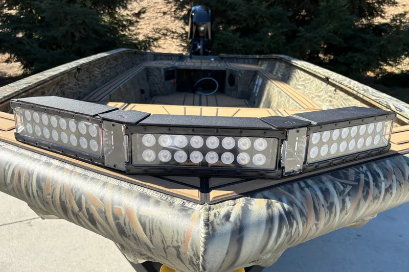 Slide: The Image of 2027 Tracker Grizzly 1650 T Prairie Wings Edition with LED light bars on camo-patterned deck. - 26