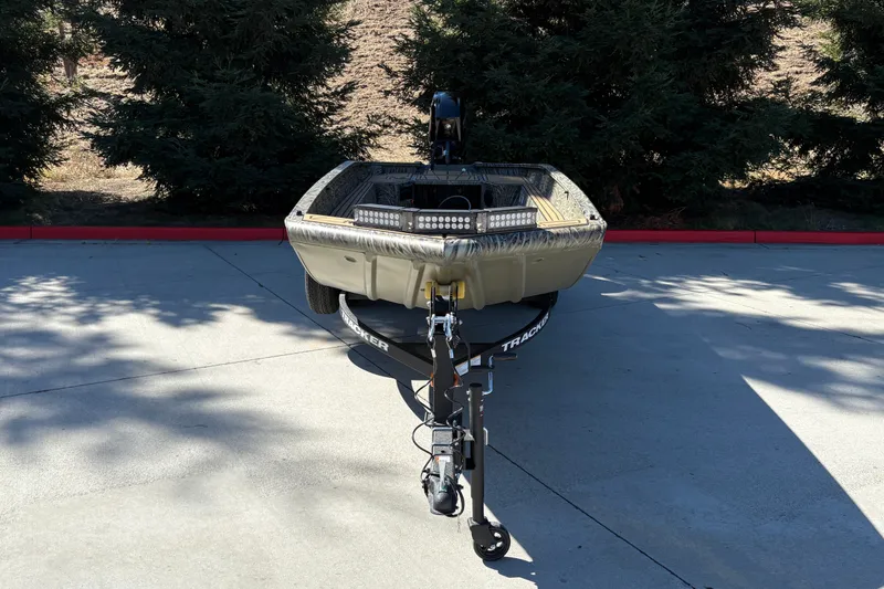 Slide: The Image of 2027 Tracker Grizzly 1650 T Prairie Wings Edition boat on trailer, parked outdoors. - 14